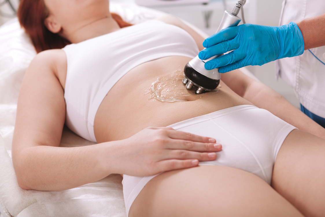 Cropped shot of a chubby woman receiving fat burning cosmetology treatment at beauty salon